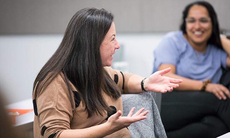 two women conversing in classroom