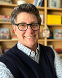 Headshot of white women with short cropped brown wearing glasses