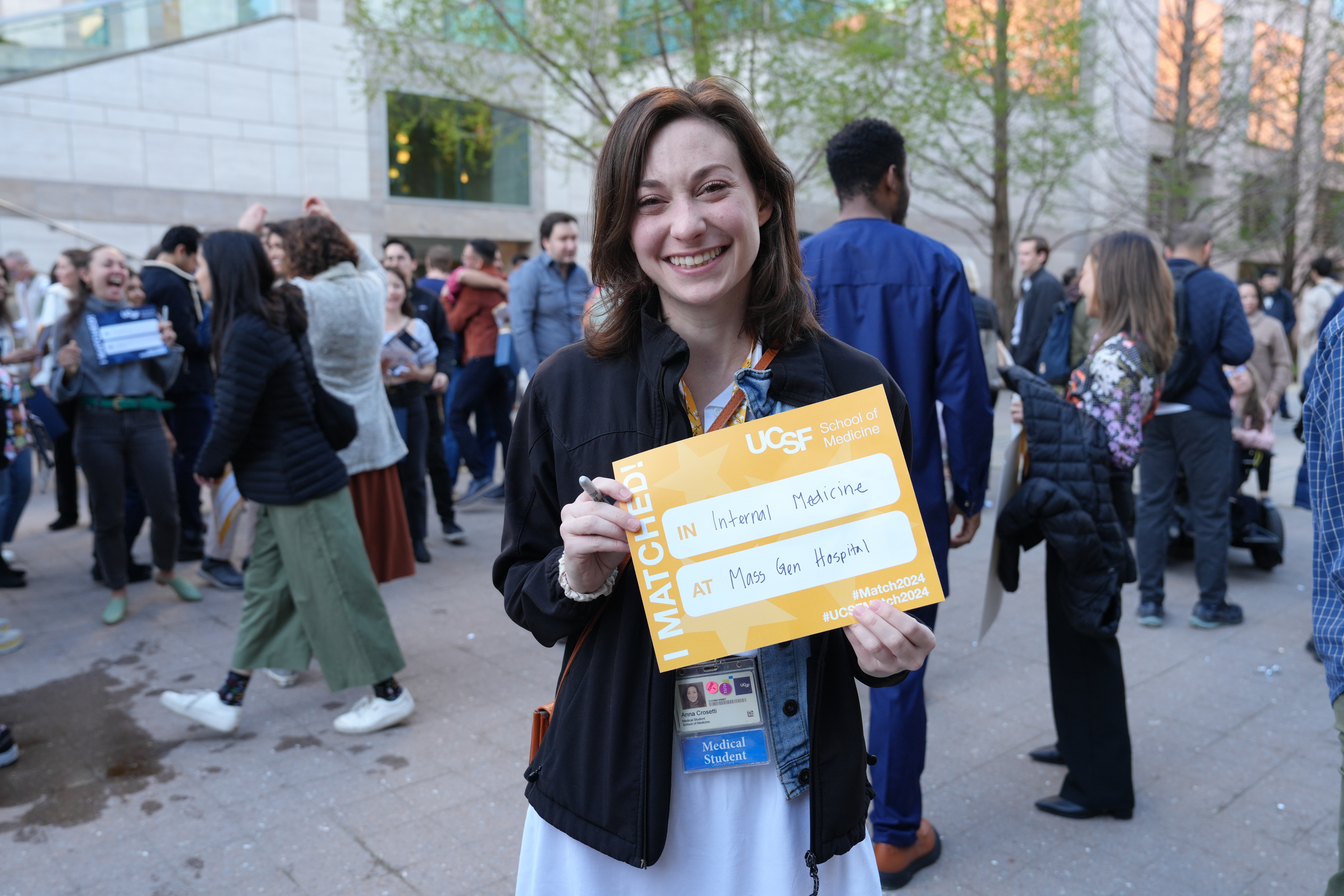 Person holding a sign standing outside in front of a crowd