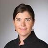 Headshot person, pulled back dark hair and black shirt