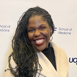 Close up of woman standing in front of a banner reading "UCSF School of Medicine"