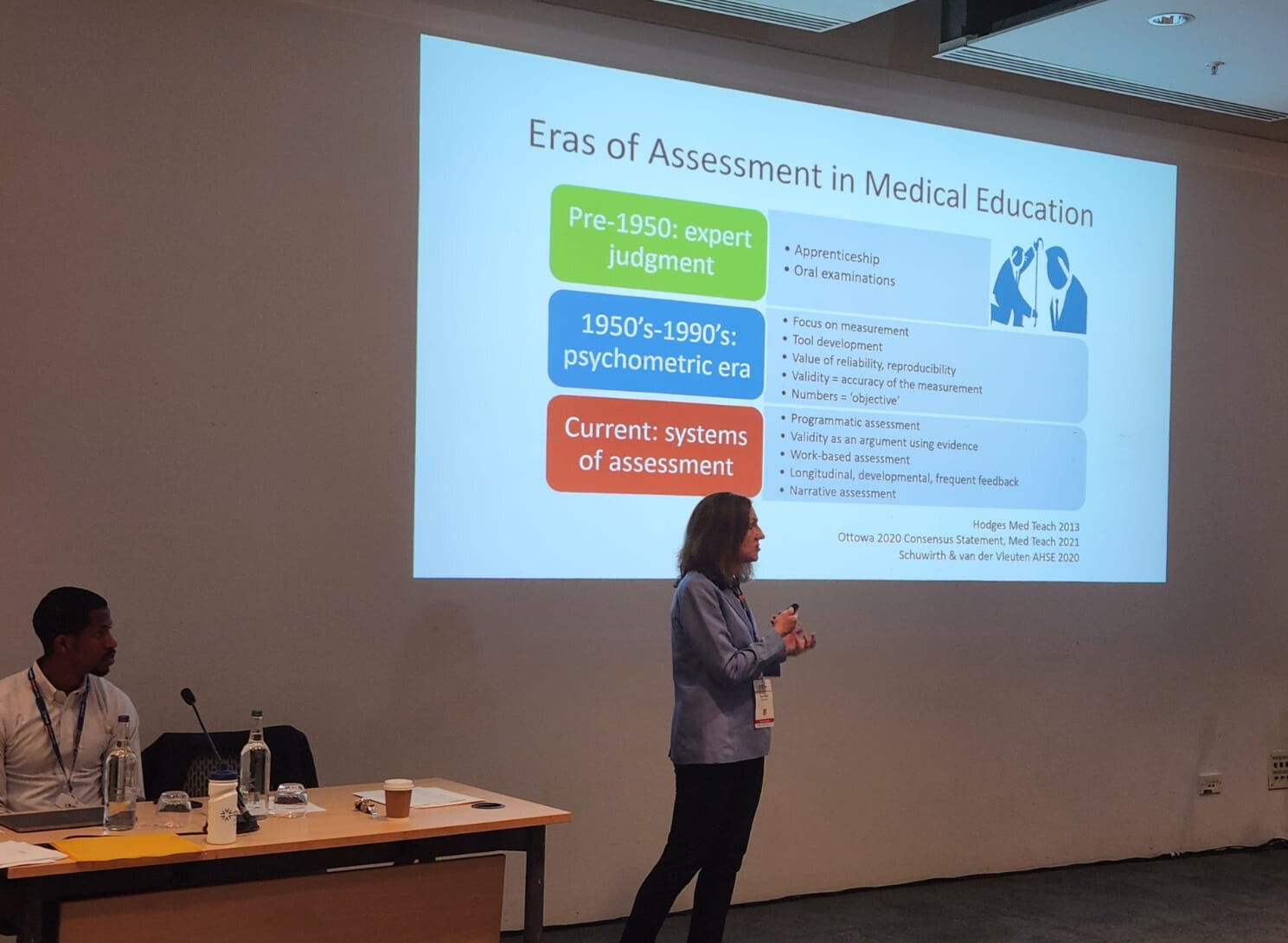 A person presenting in front of a screen