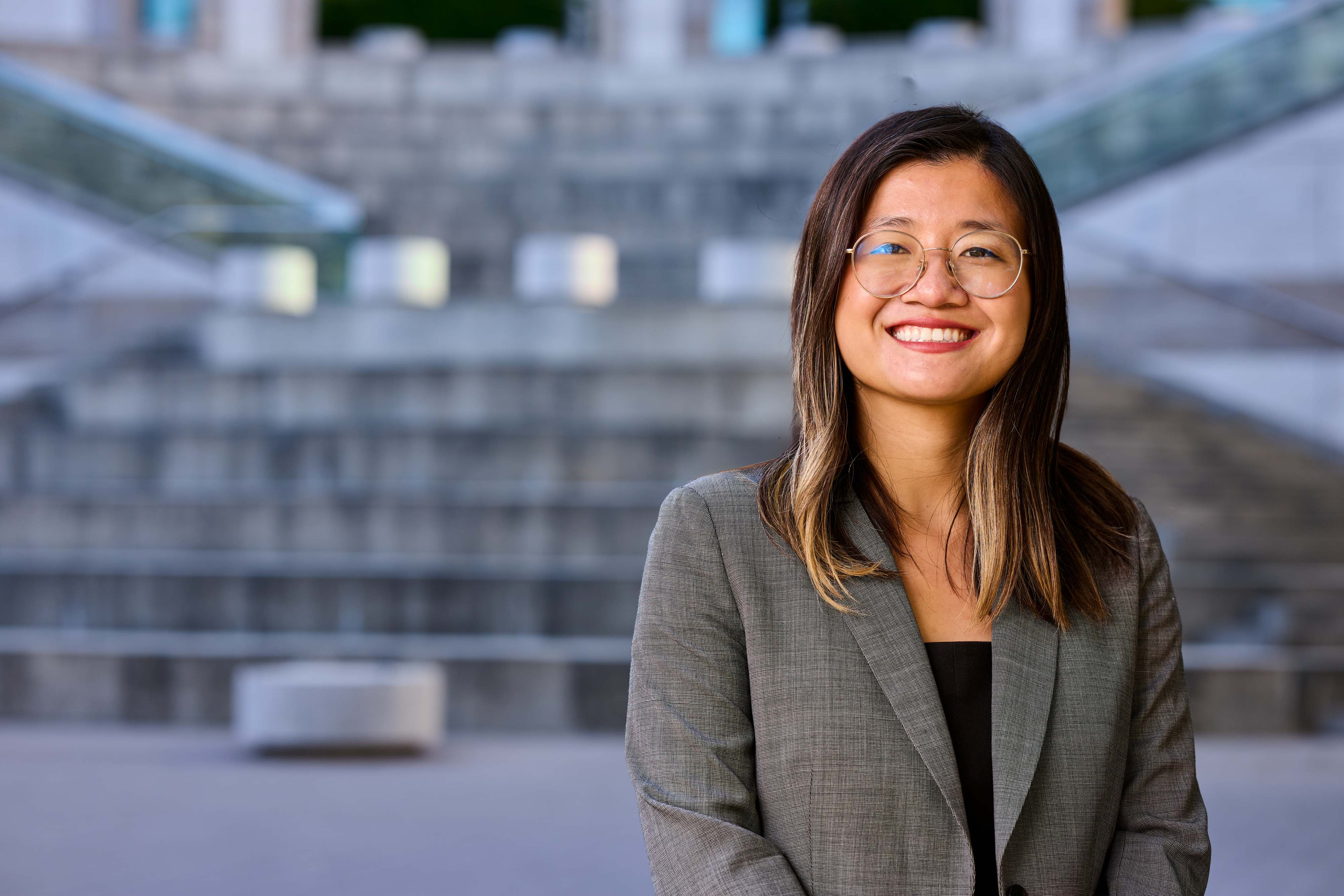 a person smiling in front of a building