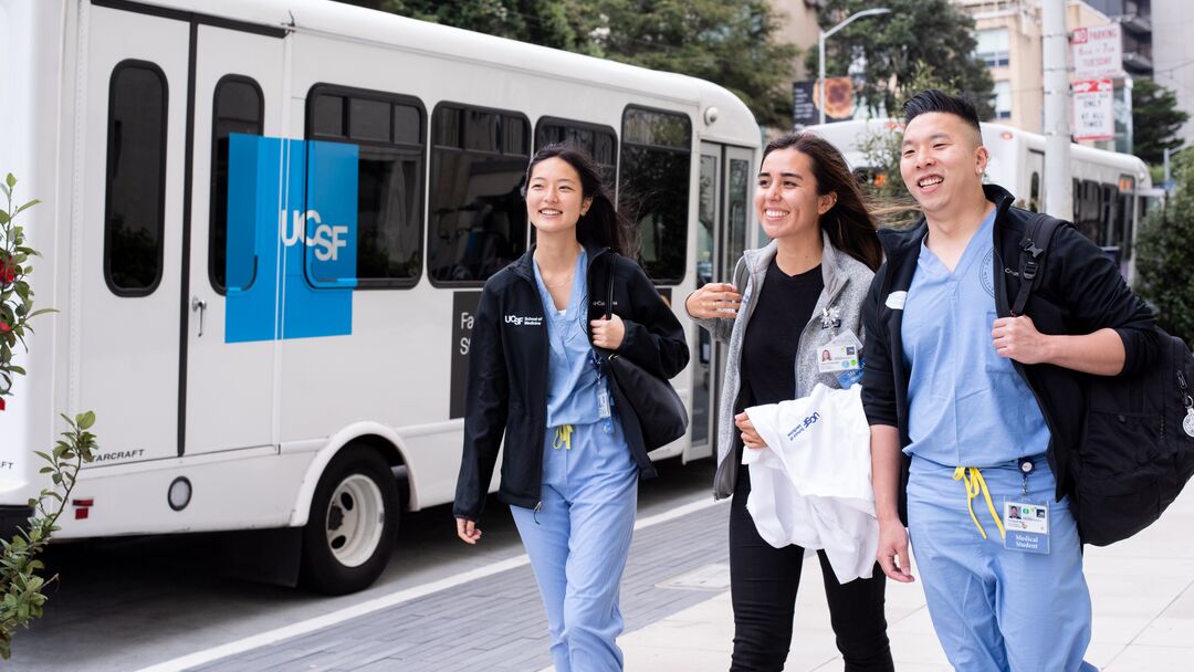 residents walking with a UCSF shuttle in the background