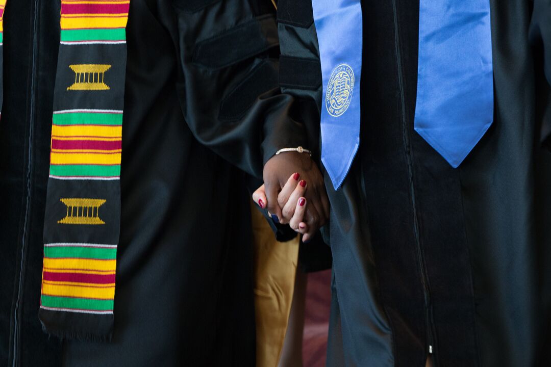 Graduates holding hands