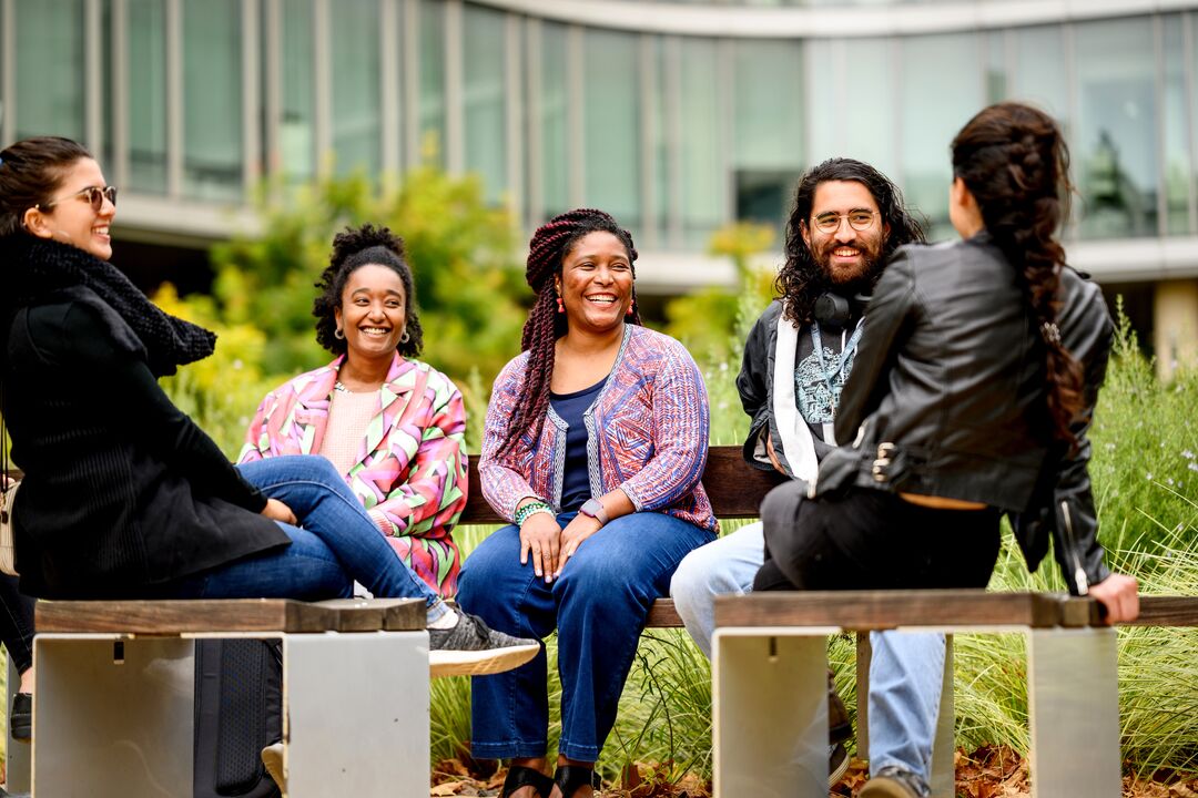 a group of people smiling and talking outside
